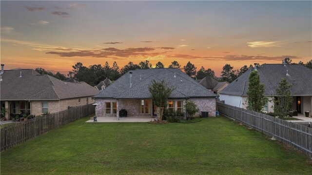 1104 Cypress Crossing Dr, Madisonville, LA 70447 - back of property at dusk with a patio area and a fenced backyard