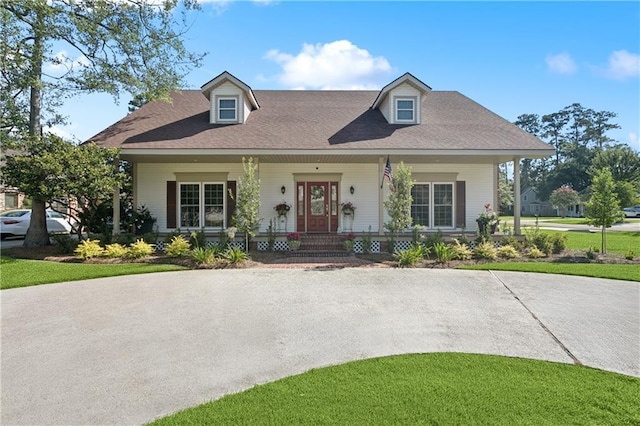 925 Winona Dr, Mandeville, LA 70471 - cape cod home featuring covered porch, a front yard, and a shingled roof