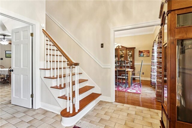 925 Winona Dr, Mandeville, LA 70471 - entryway featuring stairs, ornamental molding, a ceiling fan, and light tile patterned flooring