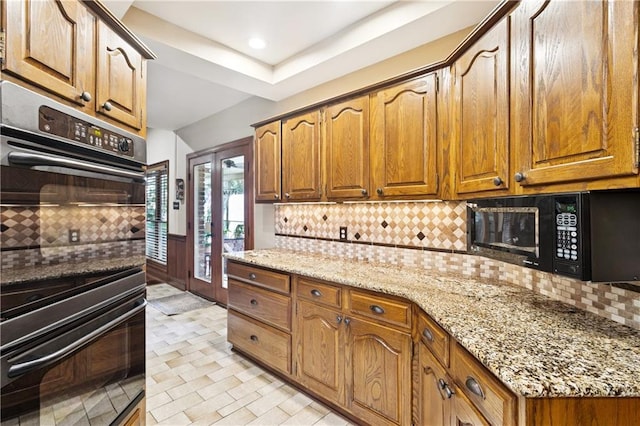 925 Winona Dr, Mandeville, LA 70471 - kitchen with black appliances, backsplash, light stone counters, and recessed lighting