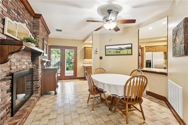 925 Winona Dr, Mandeville, LA 70471 - dining space with a fireplace, ceiling fan, and light wood-style flooring