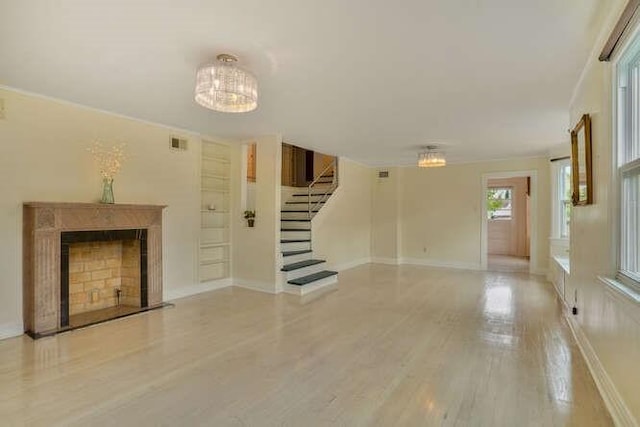 419 W William David Pkwy, Metairie, LA 70005 - unfurnished living room featuring stairway, wood finished floors, a chandelier, and a fireplace
