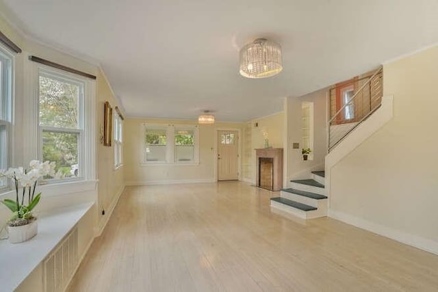 419 W William David Pkwy, Metairie, LA 70005 - unfurnished living room featuring light wood-type flooring, stairway, and a chandelier
