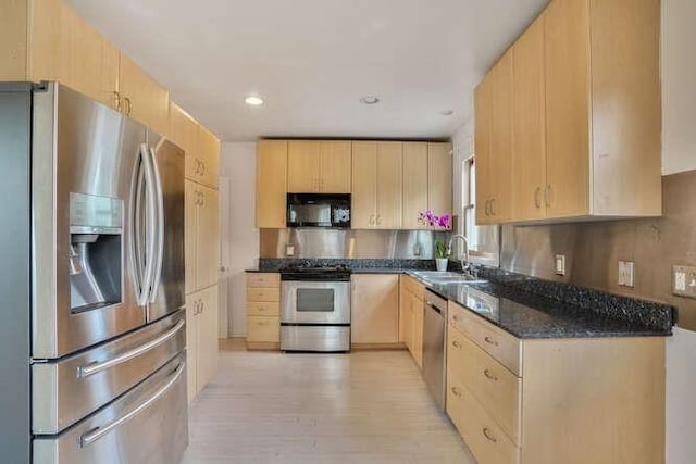 419 W William David Pkwy, Metairie, LA 70005 - kitchen featuring appliances with stainless steel finishes, light brown cabinetry, light wood-style flooring, dark stone counters, and recessed lighting