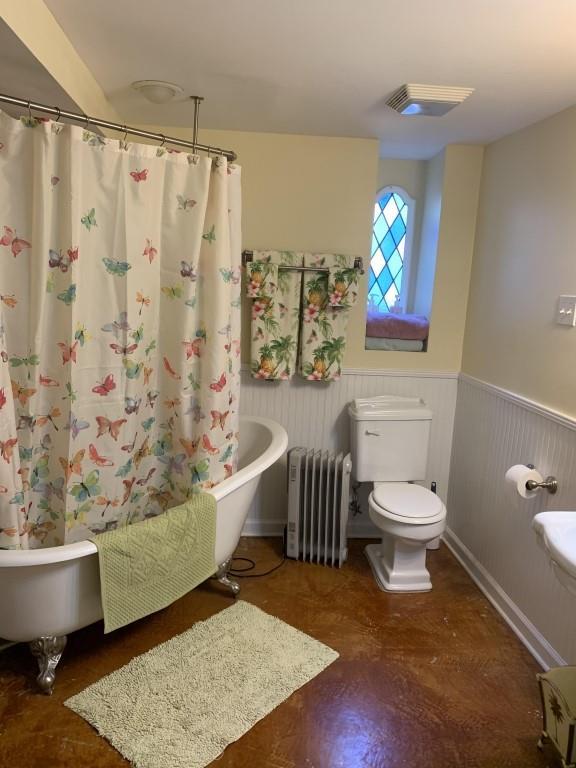 2527 Calhoun St, New Orleans, LA 70118 - full bathroom featuring radiator heating unit and wainscoting
