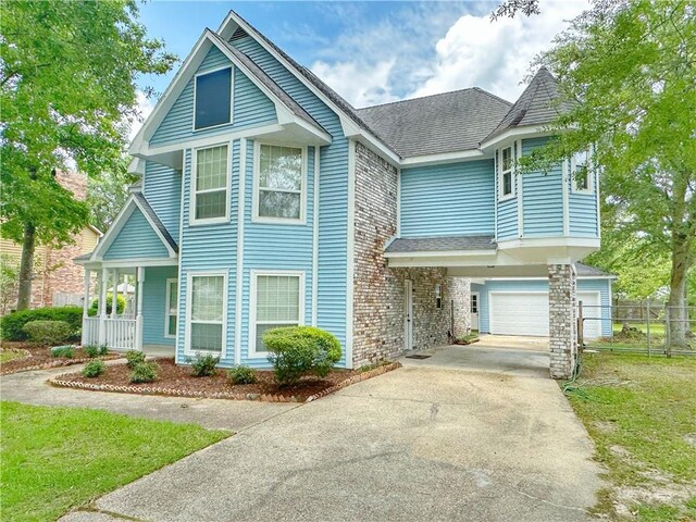 118 Golden Pheasant Dr, Slidell, LA 70461 - victorian-style house featuring driveway, a shingled roof, a garage, and covered porch