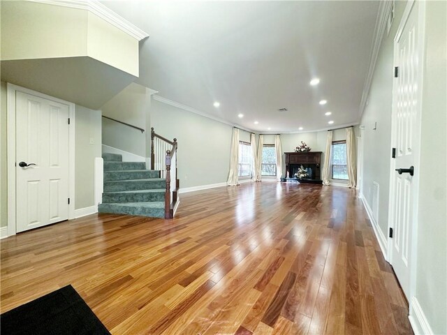 118 Golden Pheasant Dr, Slidell, LA 70461 - unfurnished living room featuring stairs, crown molding, wood finished floors, recessed lighting, and a fireplace