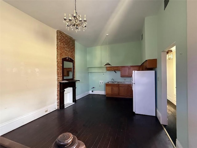 223335 Baronne St, New Orleans, LA 70113 - kitchen featuring freestanding refrigerator, a chandelier, dark wood finished floors, a towering ceiling, and decorative light fixtures