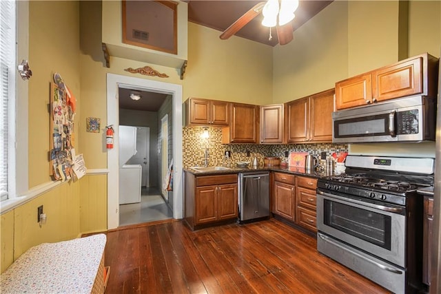 21921 Vallette St, New Orleans, LA 70114 - kitchen with appliances with stainless steel finishes, dark wood-style flooring, ceiling fan, brown cabinetry, and wainscoting