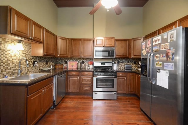 21921 Vallette St, New Orleans, LA 70114 - kitchen featuring appliances with stainless steel finishes, brown cabinetry, dark countertops, ceiling fan, and a towering ceiling