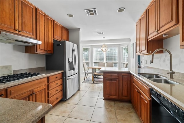 4301 Napoli Dr, Metairie, LA 70002 - kitchen with appliances with stainless steel finishes, under cabinet range hood, brown cabinets, a peninsula, and hanging light fixtures