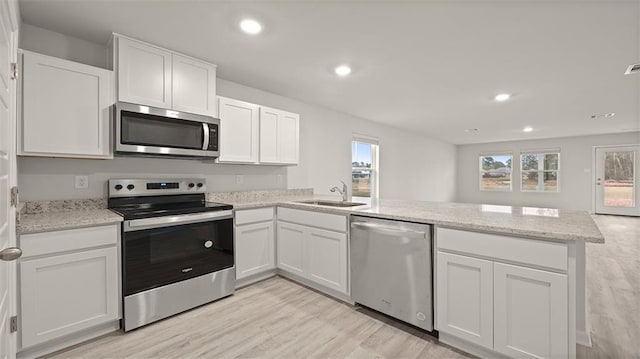 4674 Marais River Dr, Slidell, LA 70461 - kitchen featuring stainless steel appliances, a peninsula, plenty of natural light, light wood finished floors, and recessed lighting
