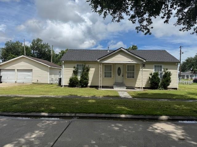 40 Gibbs Dr, Chalmette, LA 70043 - view of front of home with a garage, a front yard, and an outbuilding