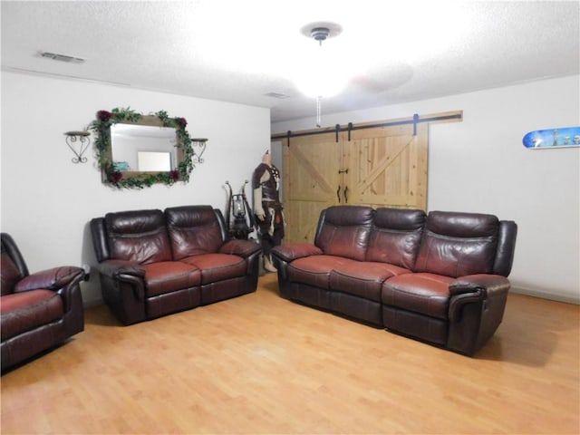 29000 Craig Dr, Hammond, LA 70403 - living room with a barn door, wood finished floors, and a textured ceiling