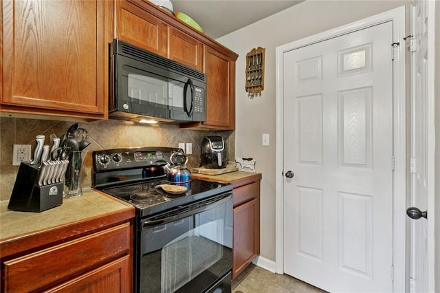 17126 Beacon St, Ponchatoula, LA 70454 - kitchen with black appliances, brown cabinetry, tile counters, backsplash, and light tile patterned flooring