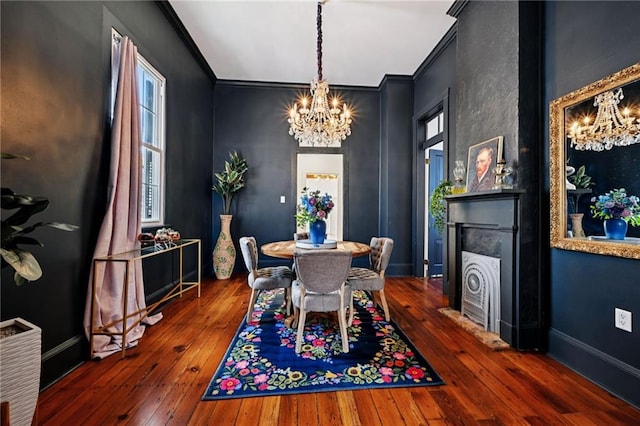 332 Olivier St, New Orleans, LA 70114 - dining room featuring a chandelier, a fireplace, ornamental molding, and hardwood / wood-style flooring