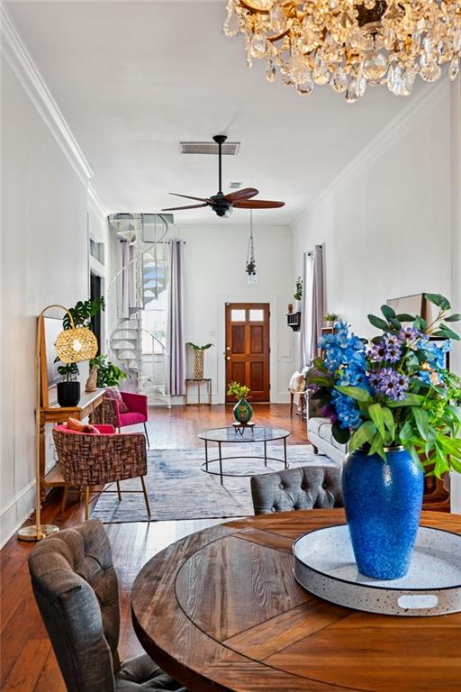 332 Olivier St, New Orleans, LA 70114 - living room with a chandelier, crown molding, hardwood / wood-style floors, and a ceiling fan