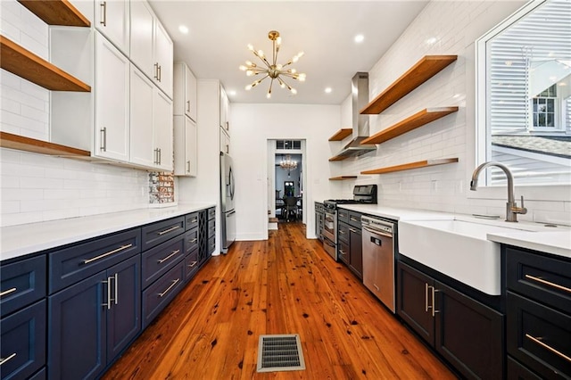 332 Olivier St, New Orleans, LA 70114 - kitchen with open shelves, stainless steel appliances, a chandelier, white cabinetry, and ventilation hood