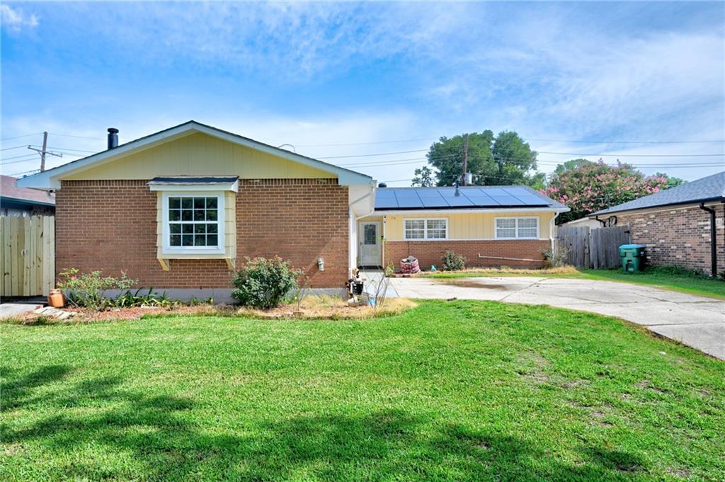 210 Incarnate Word Dr, Kenner, LA 70065 - view of front facade featuring brick siding, roof mounted solar panels, and driveway