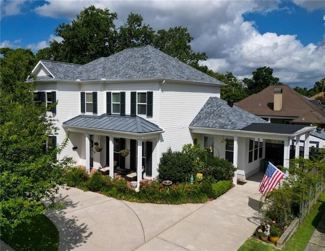 242 Douglas Dr, New Orleans, LA 70123 - view of front of home featuring a porch, a standing seam roof, driveway, a metal roof, and a shingled roof
