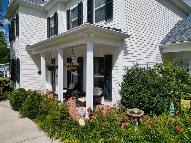 242 Douglas Dr, New Orleans, LA 70123 - entrance to property with covered porch and a shingled roof