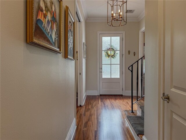 242 Douglas Dr, New Orleans, LA 70123 - entryway featuring stairway, a chandelier, dark wood finished floors, and ornamental molding