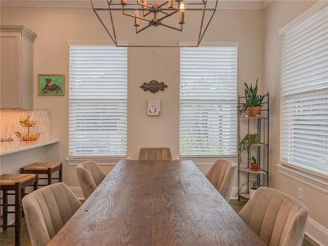 242 Douglas Dr, New Orleans, LA 70123 - dining space featuring a chandelier, crown molding, and healthy amount of natural light