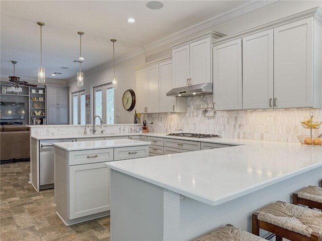 242 Douglas Dr, New Orleans, LA 70123 - kitchen with a peninsula, gas stovetop, under cabinet range hood, a ceiling fan, and stone finish floors