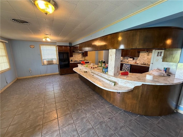 652 Central Ave, Reserve, LA 70084 - kitchen featuring black appliances, light countertops, a peninsula, and dark tile patterned flooring