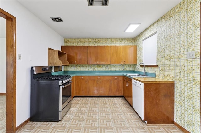 2417 Maine Ave, Metairie, LA 70003 - kitchen featuring stainless steel range with gas cooktop, premium range hood, white dishwasher, brown cabinets, and decorative backsplash