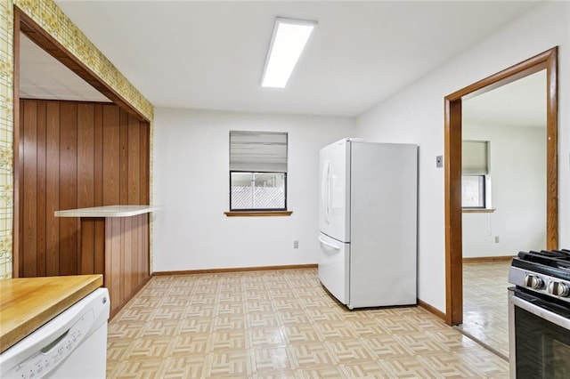 2417 Maine Ave, Metairie, LA 70003 - kitchen featuring white appliances, healthy amount of natural light, wood walls, and butcher block counters