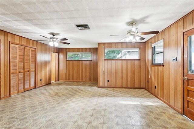 2417 Maine Ave, Metairie, LA 70003 - empty room featuring plenty of natural light, a ceiling fan, light flooring, and wood walls