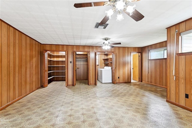 2417 Maine Ave, Metairie, LA 70003 - unfurnished living room featuring a ceiling fan, washer / dryer, wooden walls, and light floors