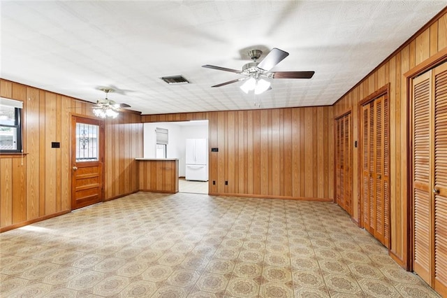 2417 Maine Ave, Metairie, LA 70003 - unfurnished living room featuring a ceiling fan, wooden walls, and light flooring