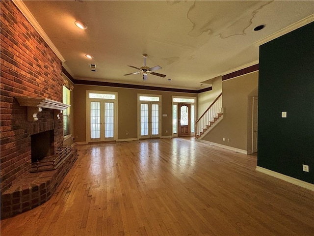 72075 Gum St, Abita Springs, LA 70420 - unfurnished living room featuring ornamental molding, a ceiling fan, wood finished floors, a brick fireplace, and brick wall