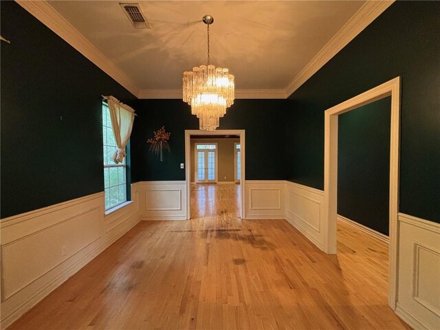 72075 Gum St, Abita Springs, LA 70420 - unfurnished dining area featuring a chandelier, light wood-style flooring, wainscoting, and crown molding