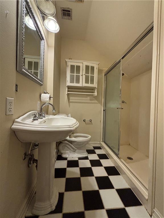 72075 Gum St, Abita Springs, LA 70420 - bathroom featuring tile patterned floors, a stall shower, and lofted ceiling