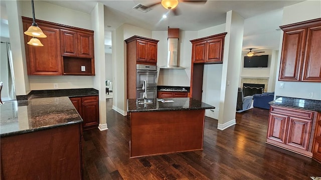 181 Latigue Rd, Avondale, LA 70094 - kitchen with ceiling fan, double oven, wall chimney range hood, and dark wood-style flooring