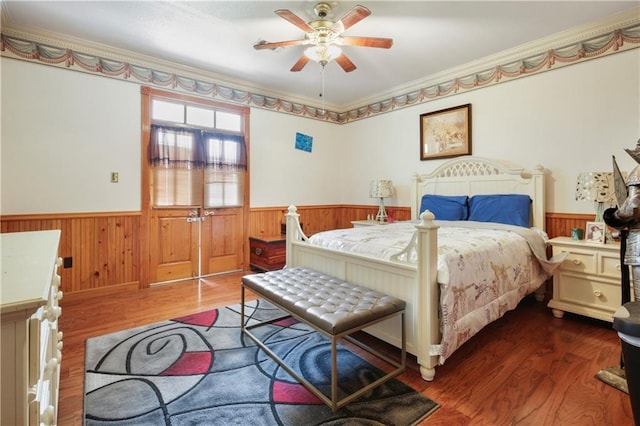 60222 N Bell Rd, Amite, LA 70422 - bedroom with wainscoting, ornamental molding, wood finished floors, wood walls, and ceiling fan