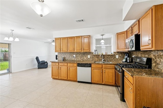 3809 N Woodlawn Ave, Metairie, LA 70006 - kitchen featuring stainless steel appliances, tasteful backsplash, brown cabinets, dark stone countertops, and light tile patterned floors
