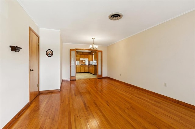 2209 Athania Pkwy, Metairie, LA 70001 - empty room with a chandelier, light wood-style floors, and crown molding