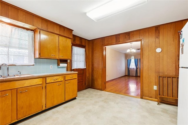 2209 Athania Pkwy, Metairie, LA 70001 - kitchen featuring brown cabinetry, light carpet, a chandelier, and wooden walls