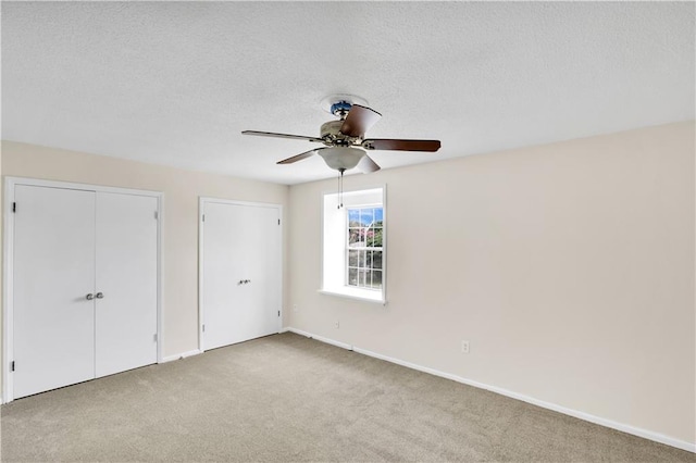 unfurnished bedroom featuring carpet floors, a textured ceiling, and ceiling fan