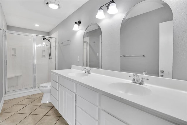 full bathroom featuring a stall shower, double vanity, and tile patterned floors