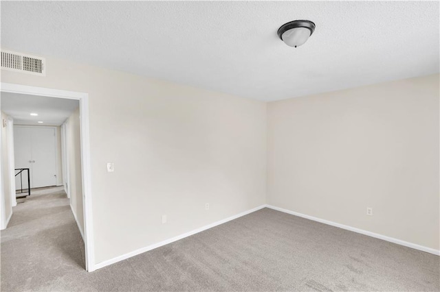 unfurnished room with carpet flooring and a textured ceiling