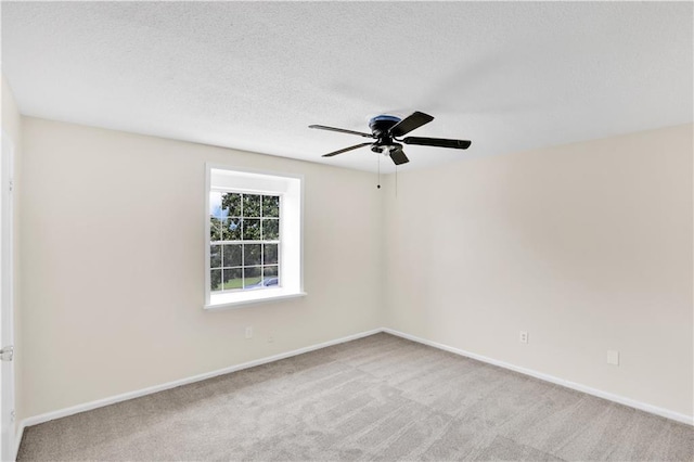 carpeted spare room featuring ceiling fan and a textured ceiling