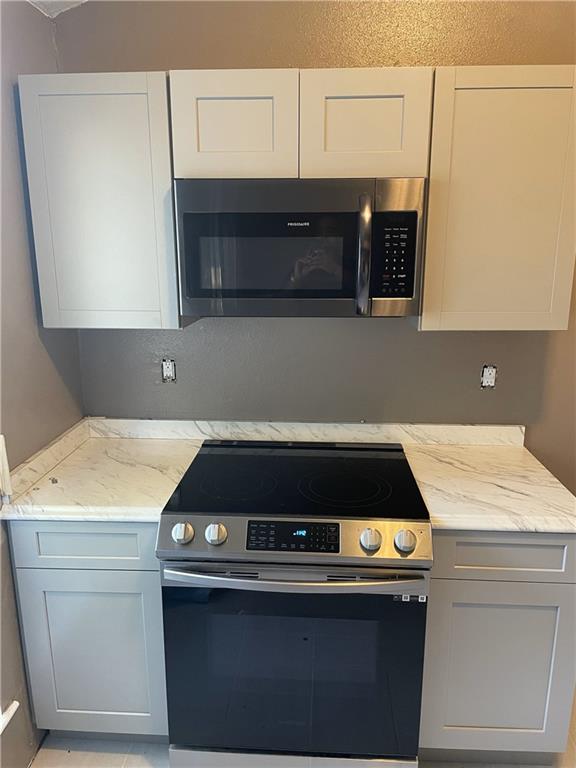 5531 New England Dr, New Orleans, LA 70129 - kitchen with appliances with stainless steel finishes and light stone counters