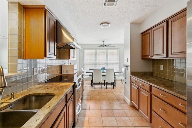 3813 N Arnoult Rd, Metairie, LA 70002 - kitchen featuring electric stove, ventilation hood, tasteful backsplash, brown cabinetry, and a textured ceiling