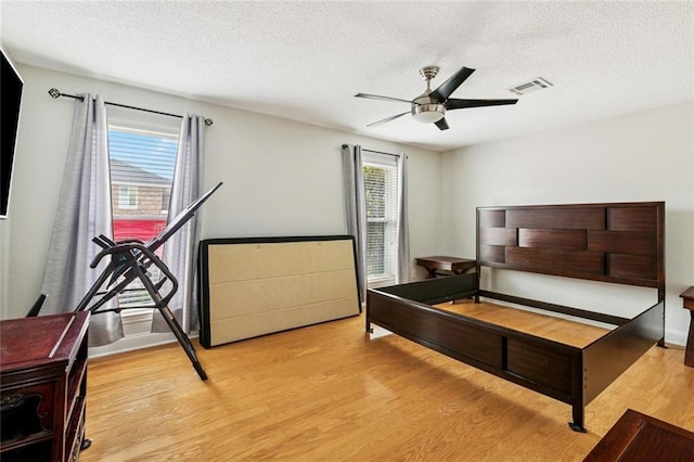 3813 N Arnoult Rd, Metairie, LA 70002 - bedroom featuring light wood finished floors, a textured ceiling, multiple windows, and ceiling fan