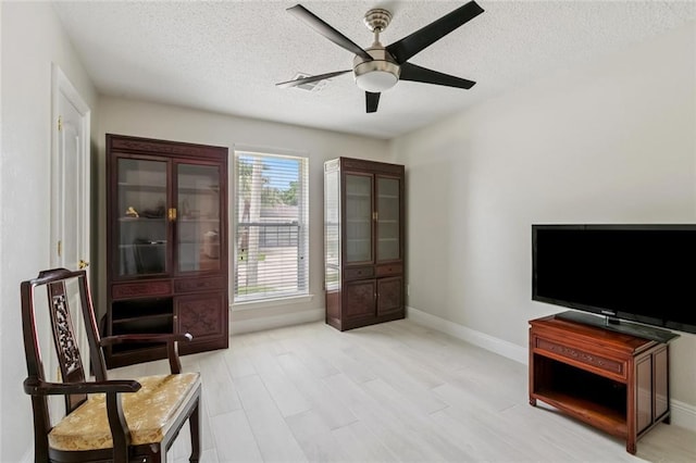 3813 N Arnoult Rd, Metairie, LA 70002 - living area featuring a ceiling fan, a textured ceiling, and light wood finished floors